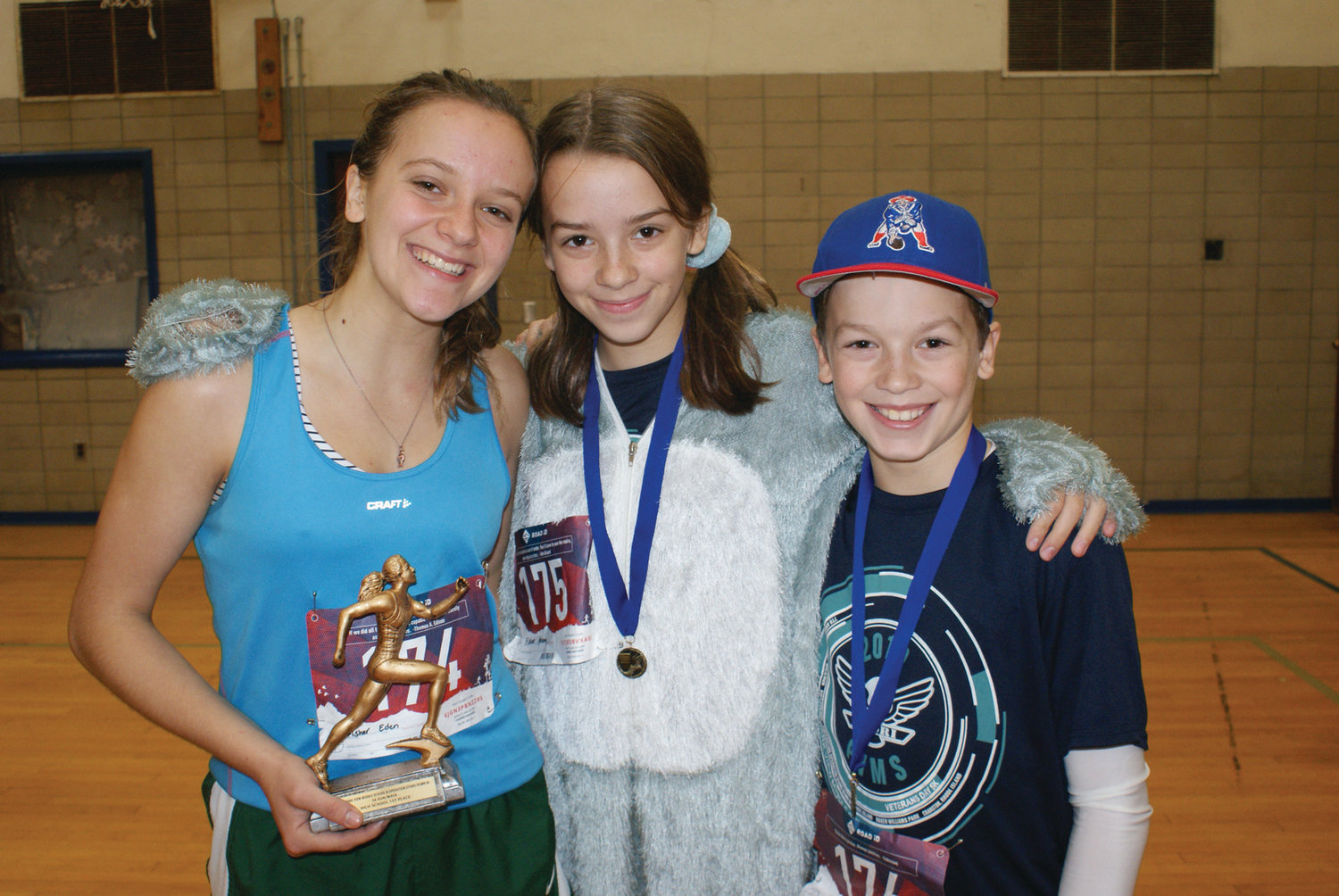 WINNING SMILE: Eden Fisher, a senior at Cranston High School East, won first place in girls high school category with a time of 21 minutes, 32 seconds. She celebrated with siblings Helena and Harrison.